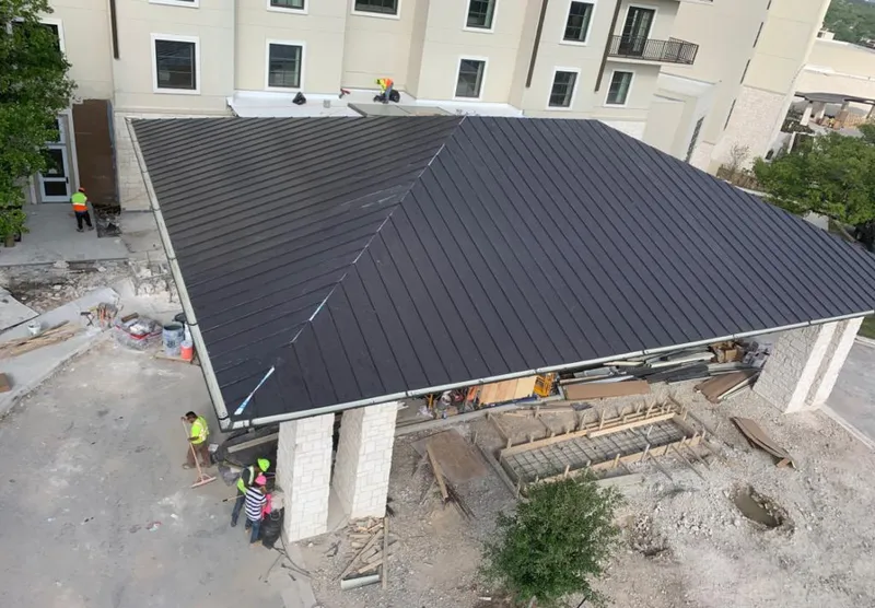 Metal roofing installation team working on a commercial building in Winchester